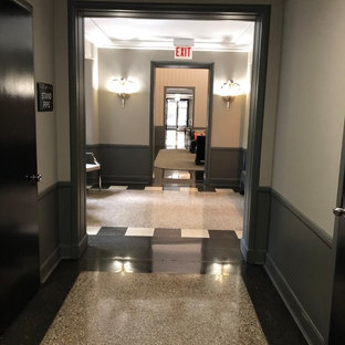Inredning av en eklektisk stor foajé, med grå väggar, terrazzogolv, en dubbeldörr, glasdörr och beiget golv