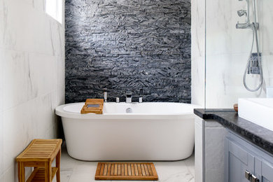 Bathroom - large transitional master gray tile and stone tile marble floor and white floor bathroom idea in DC Metro with recessed-panel cabinets, gray cabinets, a one-piece toilet, white walls, a vessel sink and granite countertops