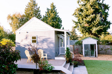 Example of a small classic gray one-story tiny house design in Seattle with a metal roof