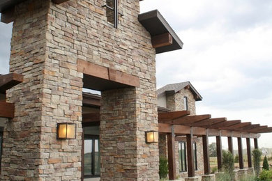 Large rustic brown one-story stone exterior home idea in San Diego with a shingle roof