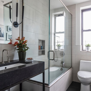Small transitional 3/4 beige tile and marble tile black floor and ceramic floor bathroom photo in Denver with open cabinets, black cabinets, a one-piece toilet, beige walls, an undermount sink, a hinged shower door and granite countertops