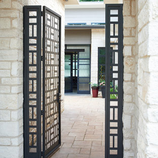 アトランタのモダンスタイルのおしゃれな家の外観 (石材サイディング、ベージュの外壁、陸屋根、戸建、金属屋根) の写真