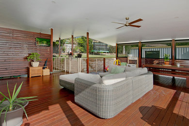 Photo of a large contemporary backyard deck in Brisbane with a roof extension.