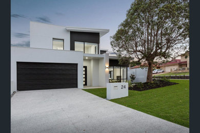 Design ideas for a mid-sized contemporary two-storey brick white house exterior in Perth with a flat roof and a metal roof.