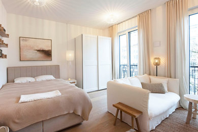 Kleines, Offenes Modernes Wohnzimmer mit weißer Wandfarbe, hellem Holzboden und braunem Boden in München