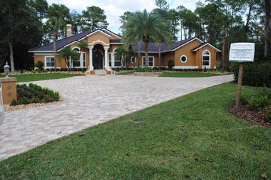 This is an example of a large mediterranean one-storey stucco brown exterior in Orlando with a gable roof.