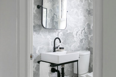 Photo of a small modern cloakroom in New York with a console sink, a freestanding vanity unit and wallpapered walls.
