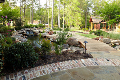 Design ideas for a mid-sized rustic partial sun backyard brick water fountain landscape in New Orleans for summer.