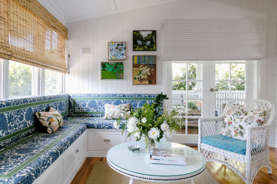 This is an example of a country living room in Brisbane with white walls, medium hardwood floors, brown floor, vaulted and planked wall panelling.