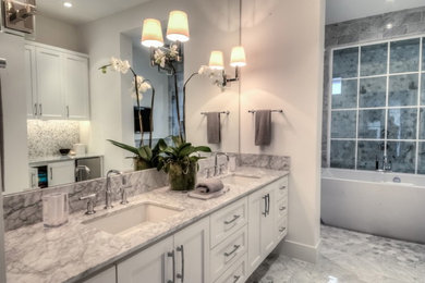 ヒューストンにある高級なコンテンポラリースタイルのおしゃれなマスターバスルーム (白い壁、アンダーカウンター洗面器、白いキャビネット) の写真