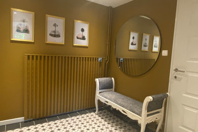 Idées déco pour un hall d'entrée éclectique avec un mur jaune, un sol en carrelage de céramique, une porte simple et une porte métallisée.