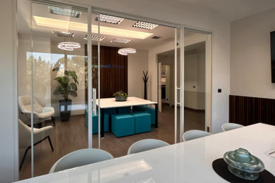 Foto di un grande ufficio minimalista con pavimento in laminato, pavimento marrone e boiserie