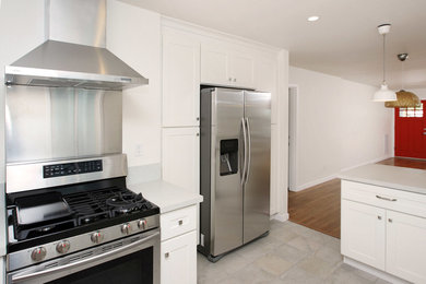 Small trendy galley porcelain tile and gray floor open concept kitchen photo in San Francisco with an undermount sink, shaker cabinets, white cabinets, quartz countertops, stainless steel appliances, a peninsula and white countertops