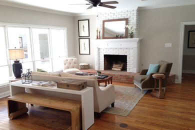 Living room - mid-sized transitional formal and enclosed medium tone wood floor living room idea in New Orleans with beige walls, a standard fireplace, a brick fireplace and no tv