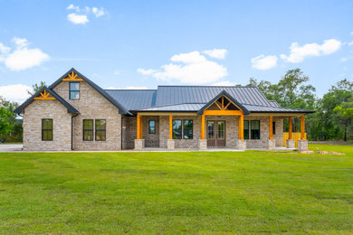 Inspiration for a mid-sized craftsman beige two-story brick exterior home remodel in Other with a metal roof and a black roof