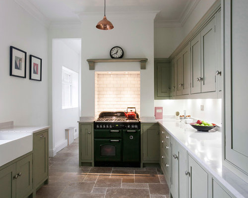 Photo of a small modern galley enclosed kitchen in Kent with a belfast sink, shaker cabinets, quartz worktops, white splashback, ceramic splashback, coloured appliances and limestone flooring.