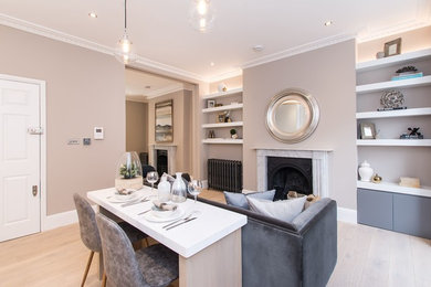 Photo of a small contemporary open plan living room in London with grey walls, medium hardwood flooring, a wood burning stove, a stone fireplace surround, a wall mounted tv and brown floors.