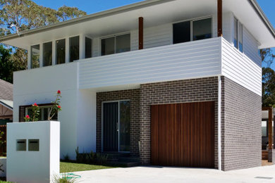 Design ideas for a contemporary multi-coloured duplex exterior in Sydney with mixed siding, a hip roof, a metal roof and a white roof.