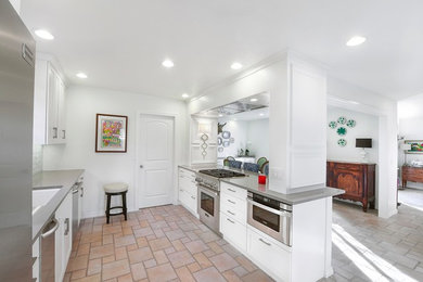Inspiration for a contemporary single-wall kitchen remodel in Oklahoma City with an undermount sink, recessed-panel cabinets, white cabinets, quartz countertops, white backsplash, glass tile backsplash, stainless steel appliances and an island