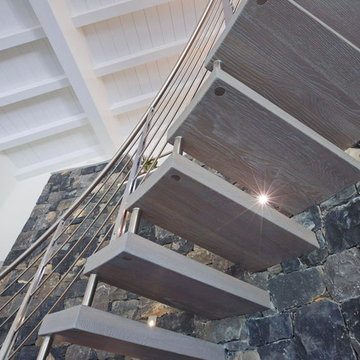 Scala sospesa con gradini in rovere e ringhiera in inox