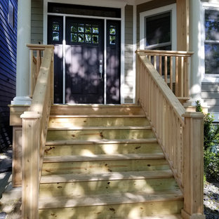 シカゴの中サイズの片開きドアヴィクトリアン調のおしゃれな玄関ドア (茶色い壁、合板フローリング、濃色木目調のドア、茶色い床) の写真