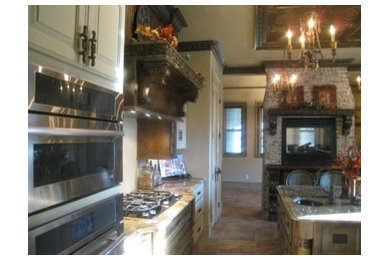 Galley kitchen in Other with granite benchtops, stainless steel appliances, travertine floors and with island.