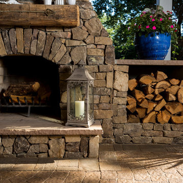 Covered outdoor area with fireplace, grill island and paver patio
