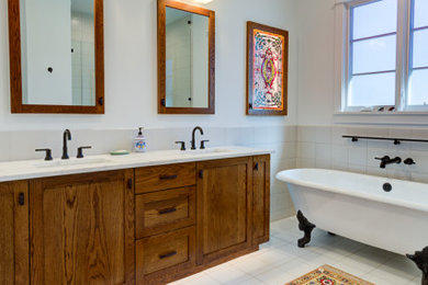 This is an example of a medium sized mediterranean ensuite bathroom in Austin with shaker cabinets, medium wood cabinets, a claw-foot bath, a double shower, a bidet, white tiles, porcelain tiles, white walls, porcelain flooring, a submerged sink, engineered stone worktops, white floors, a hinged door, white worktops, a wall niche, double sinks, a built in vanity unit and wood walls.