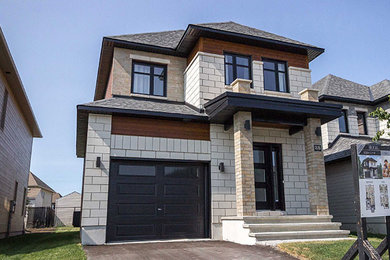 Example of a mid-sized trendy beige two-story stone house exterior design in Ottawa with a hip roof and a shingle roof