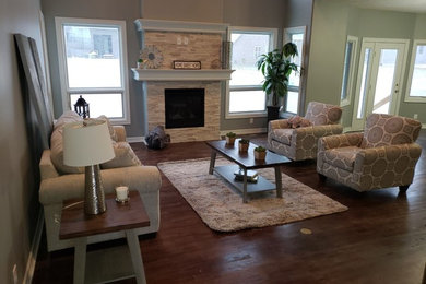 Trendy open concept dark wood floor and brown floor family room photo in Omaha with gray walls, a standard fireplace, a stone fireplace and a wall-mounted tv