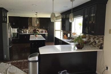 Inspiration for a large contemporary galley dark wood floor eat-in kitchen remodel in DC Metro with an undermount sink, flat-panel cabinets, black cabinets, quartzite countertops, beige backsplash, mosaic tile backsplash, stainless steel appliances and two islands