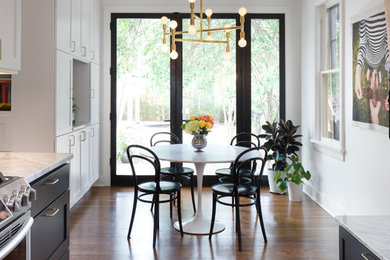 Example of a mid-sized minimalist galley dark wood floor and brown floor eat-in kitchen design in Austin with an undermount sink, shaker cabinets, black cabinets, marble countertops, white backsplash, ceramic backsplash, stainless steel appliances and no island