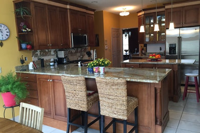Inspiration for a mid-sized transitional l-shaped ceramic tile eat-in kitchen remodel in Cedar Rapids with medium tone wood cabinets, stainless steel appliances and two islands