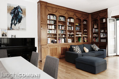 Modelo de sala de estar con biblioteca abierta contemporánea de tamaño medio con paredes blancas, suelo de madera clara y suelo marrón