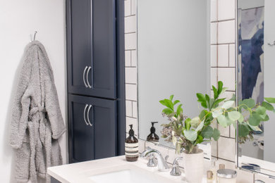 Inspiration for a mid-sized transitional master white tile and ceramic tile ceramic tile and beige floor alcove shower remodel in Other with shaker cabinets, blue cabinets, a two-piece toilet, white walls, an undermount sink, quartz countertops, a hinged shower door and white countertops