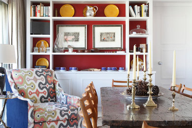 Contemporary dining room in London with red walls, dark hardwood flooring and feature lighting.