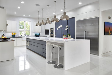 Large minimalist u-shaped porcelain tile and white floor eat-in kitchen photo with a farmhouse sink, flat-panel cabinets, white cabinets, quartz countertops, white backsplash, ceramic backsplash, stainless steel appliances, an island and white countertops