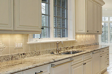 Eat-in kitchen - mid-sized traditional galley marble floor eat-in kitchen idea in Toronto with an undermount sink, raised-panel cabinets, white cabinets, granite countertops, beige backsplash, ceramic backsplash and paneled appliances