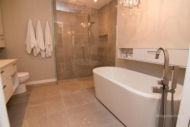Mid-sized modern master bathroom in Montreal with an undermount sink, flat-panel cabinets, white cabinets, quartzite benchtops, a freestanding tub, a curbless shower, a one-piece toilet, gray tile, porcelain tile, white walls and porcelain floors.