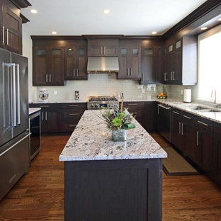 Mid-sized industrial kitchen pantry inspiration - Example of a mid-sized urban u-shaped medium tone wood floor kitchen pantry design in Ottawa with an undermount sink, shaker cabinets, dark wood cabinets, granite countertops, beige backsplash, glass tile backsplash, stainless steel appliances and an island
