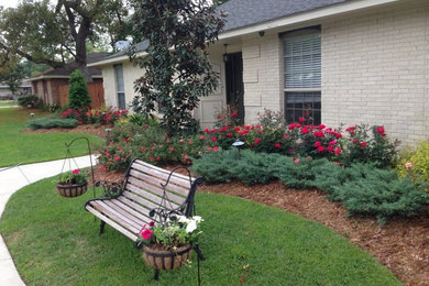 This is an example of a traditional front yard patio in New Orleans with brick pavers and no cover.