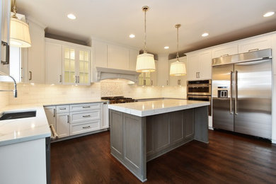 Large elegant u-shaped dark wood floor eat-in kitchen photo in Chicago with an undermount sink, recessed-panel cabinets, white cabinets, white backsplash, stainless steel appliances and an island