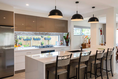Inspiration for a large contemporary galley open plan kitchen in Gold Coast - Tweed with an undermount sink, flat-panel cabinets, white cabinets, quartz benchtops, stainless steel appliances and with island.