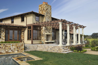 Example of a tuscan patio design in San Francisco with a fireplace