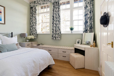Photo of a medium sized rural master bedroom in Cambridgeshire with green walls and light hardwood flooring.