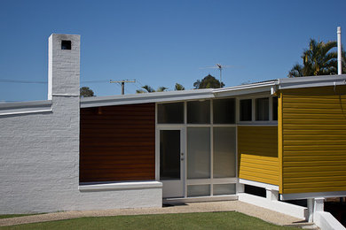 Example of a mid-century modern home design design in Cairns