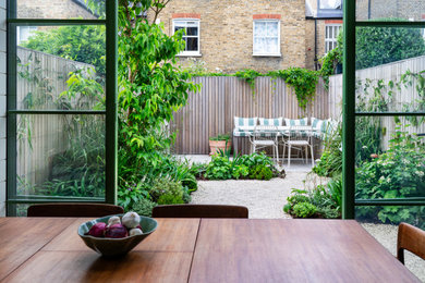 Photo of a medium sized scandinavian back patio in London with an outdoor kitchen, concrete slabs and no cover.