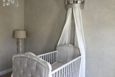Example of a mid-sized classic girl carpeted nursery design in Charlotte with gray walls