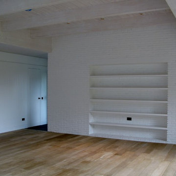 Brick Wall Partitioning Kitchen and Living Room Supporting Glulam Beams
