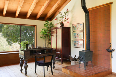 Study room - eclectic freestanding desk medium tone wood floor and exposed beam study room idea in Other with white walls and a brick fireplace